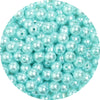 A close-up view of small, light blue imitation pearl beads scattered in a pile.