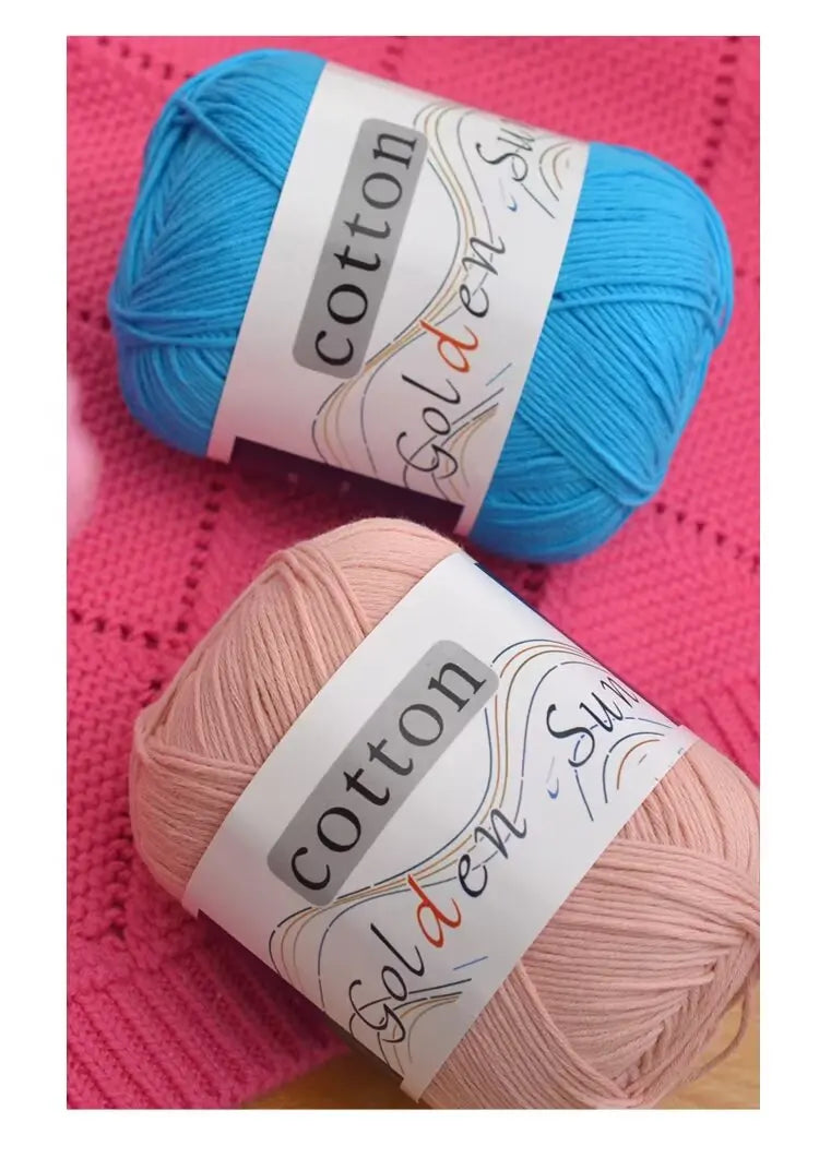 A ball of light blue cotton knitting yarn labeled golden sun.