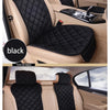 Black universal car seat protector with quilted fabric and anti-slip backing installed in a car interior.