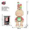 A fully assembled bear figure made of pink and yellow micro building blocks with stacked green and red accessories.
