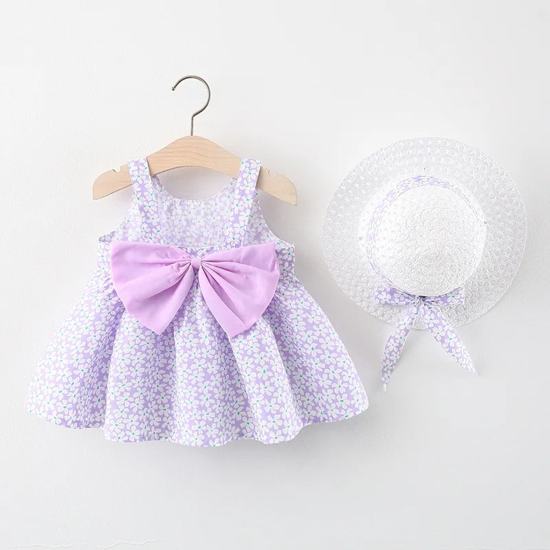 A purple floral baby girl summer dress and sunhat set with bow details displayed on a hanger.