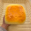 A golden loaf of bread is placed in a woven basket.