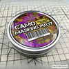 A tin of Camo Masking Putty for model painting with a barcode and weight label on a grid background.