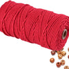 A spool of bright red natural cotton macrame rope for crafts and decor.