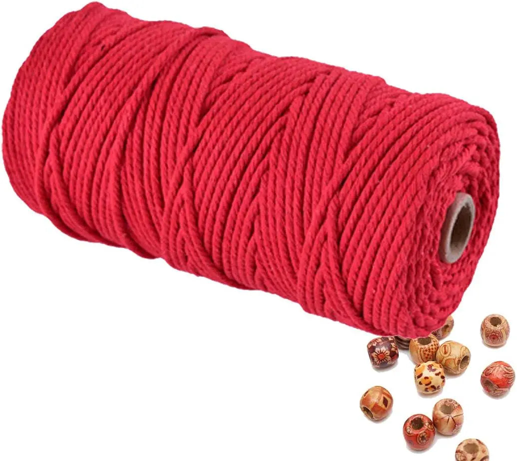 A spool of bright red natural cotton macrame rope for crafts and decor.