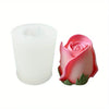 A pink rose silicone candle mold with green leaves shown next to a white candle.