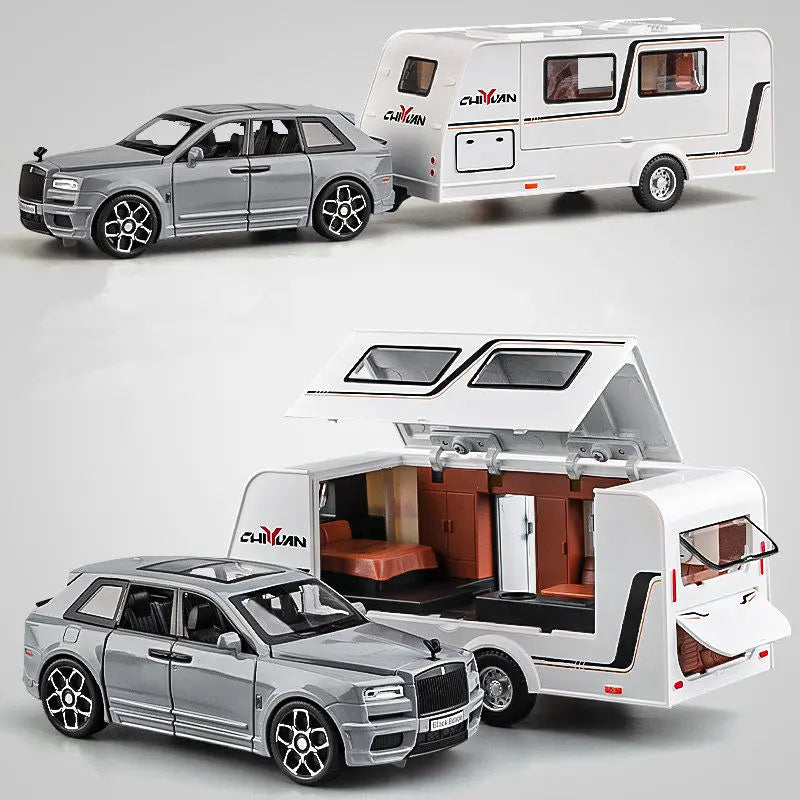 A silver diecast metal RV camper truck model with a white camper unit and a separate car model.