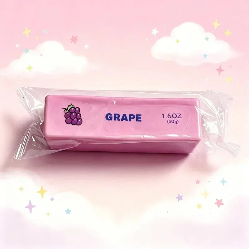 A pink squishy fidget toy shaped like a grape is packaged in clear plastic against a light pink background.