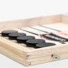 Table de foosball en bois avec des raquettes noires et blanches sur une surface en bois clair.