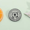 Black enamel pin featuring a detailed illustration of a cat with an open mouth and stars, labeled as a honored member of the 