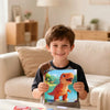 A young boy holds a completed 3D sticker art puzzle kit featuring dinosaur and animal designs.