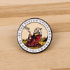 An enamel pin featuring a bearded man smoking a pipe against a yellow background.