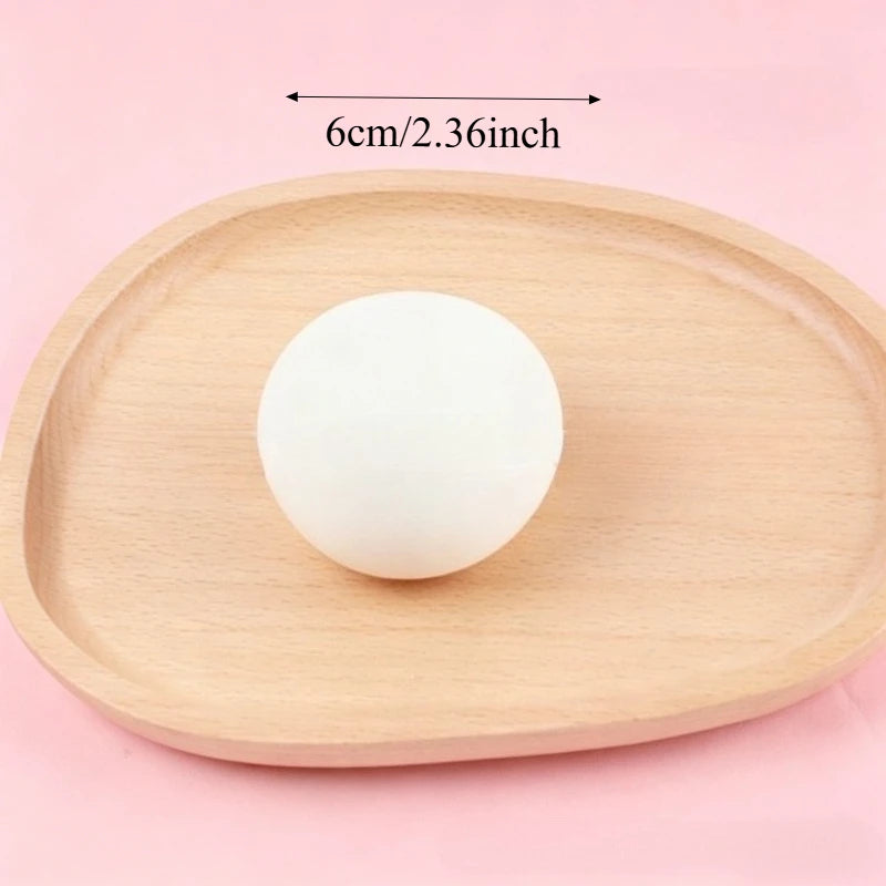 A white squishy bread stress ball resting on a light wooden tray.