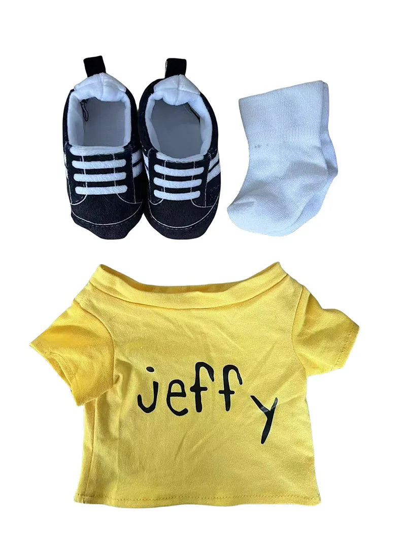A yellow t-shirt with the name Jeffy printed on it, next to a pair of black and white socks and a hand puppet.