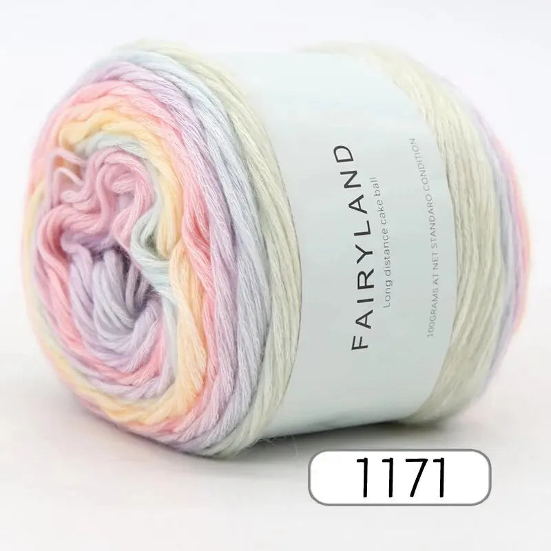 A spool of gradient rainbow yarn is shown rolled on a white label.