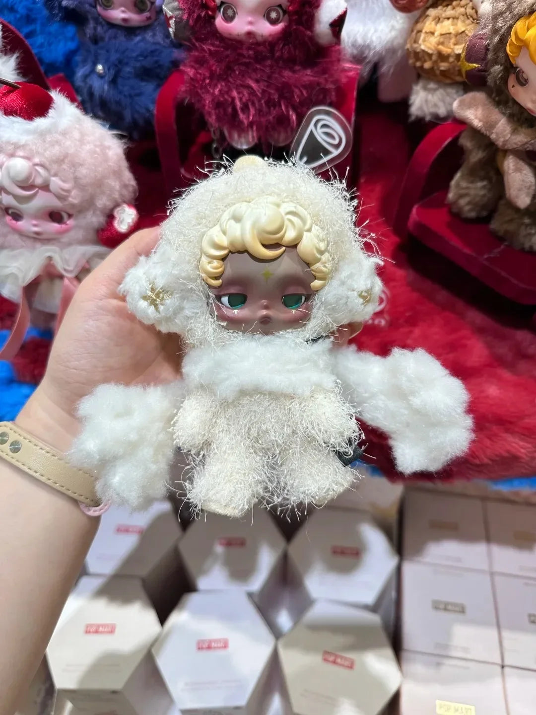 A white Skullpanda You Found Me! Series collectible figure is held against a background of other figures and packaging.