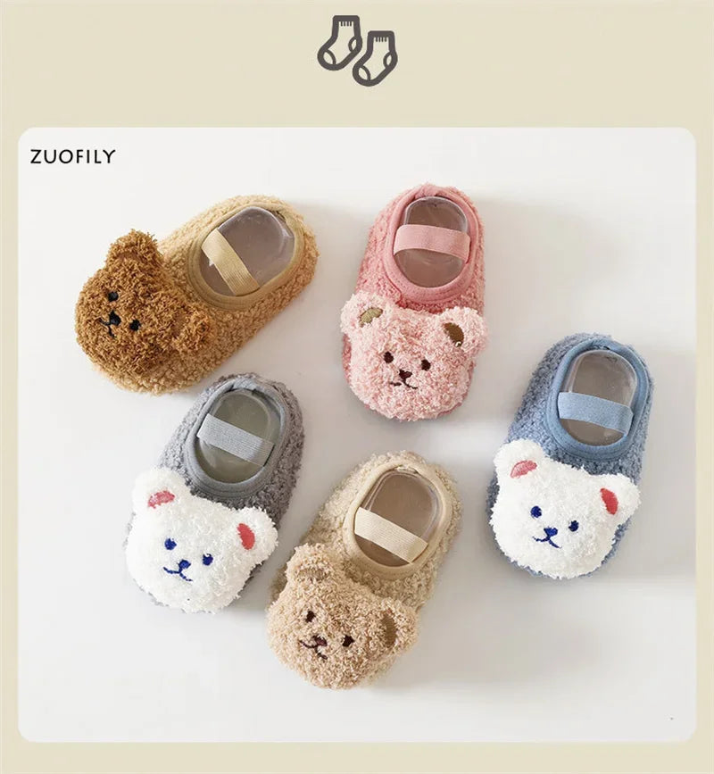 A collection of adorable cartoon bear baby booties in various soft colors and textures for infants.