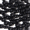 A pile of black pony beads for jewelry making and craft projects.