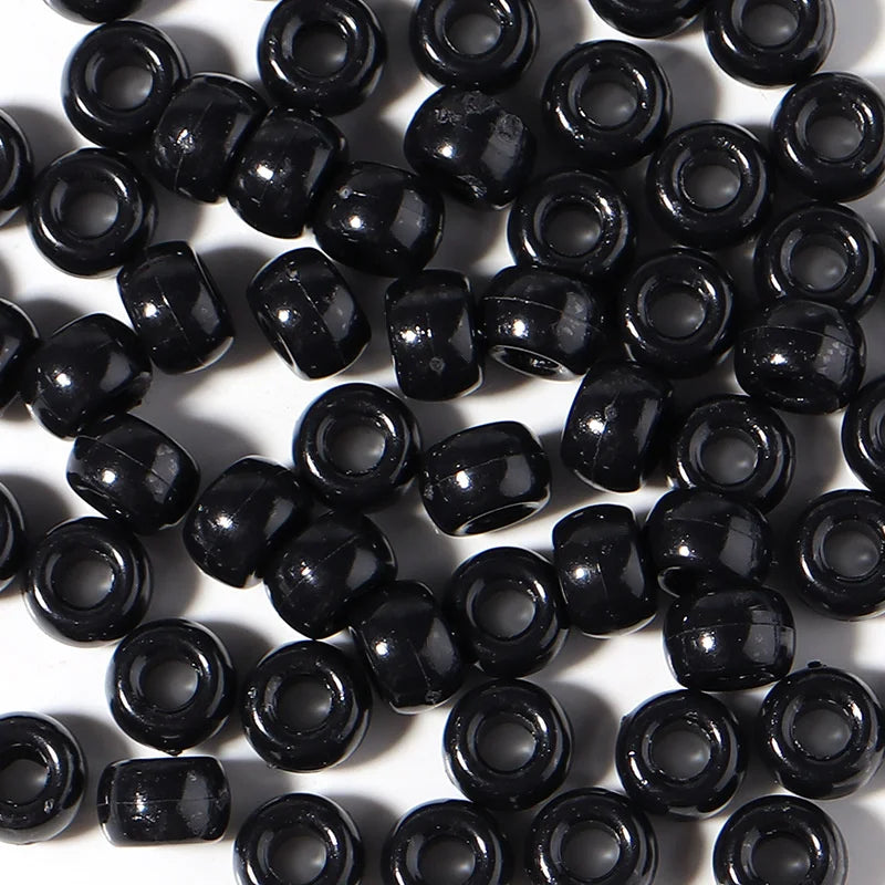 A pile of black pony beads for jewelry making and craft projects.