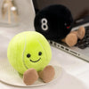 A bright lime green plush sports ball companion with small tan feet resting on a white plate.
