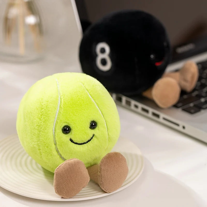 A bright lime green plush sports ball companion with small tan feet resting on a white plate.
