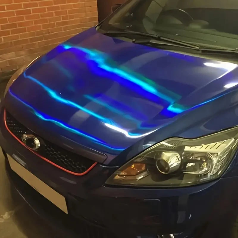 Close-up of a dark blue car hood featuring an iridescent holographic vinyl wrap effect.