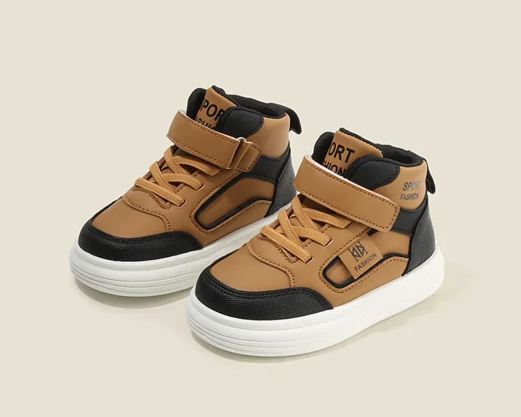 A pair of tan and black kids' high-top sneakers with easy velcro straps shown from the side.