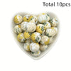 A collection of ten white and yellow floral printed silicone beads for DIY jewelry making
