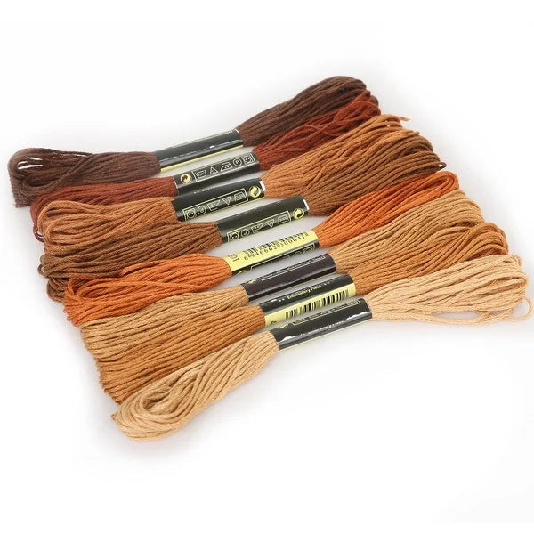 A set of multicolor embroidery floss skeins in various shades of brown and orange with a glitter finish.