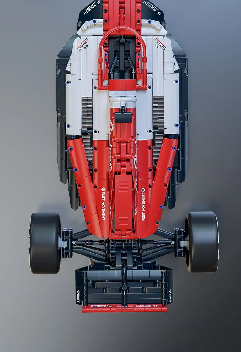 A detailed model of a formula racing car built from red and white plastic building blocks with steering and engine linkage co