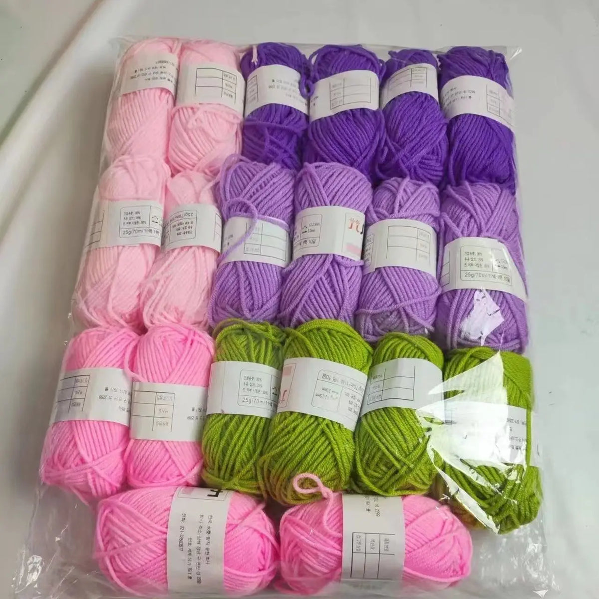 A pack of 20 skeins of soft acrylic wool yarn in various shades of pink, purple, and green for knitting and crochet.
