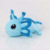 A light blue plush toy of an axolotl with blue accents, lying on a white surface.