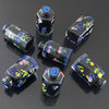 A set of seven floral resin potion bottle polyhedral dice displayed on a dark surface.