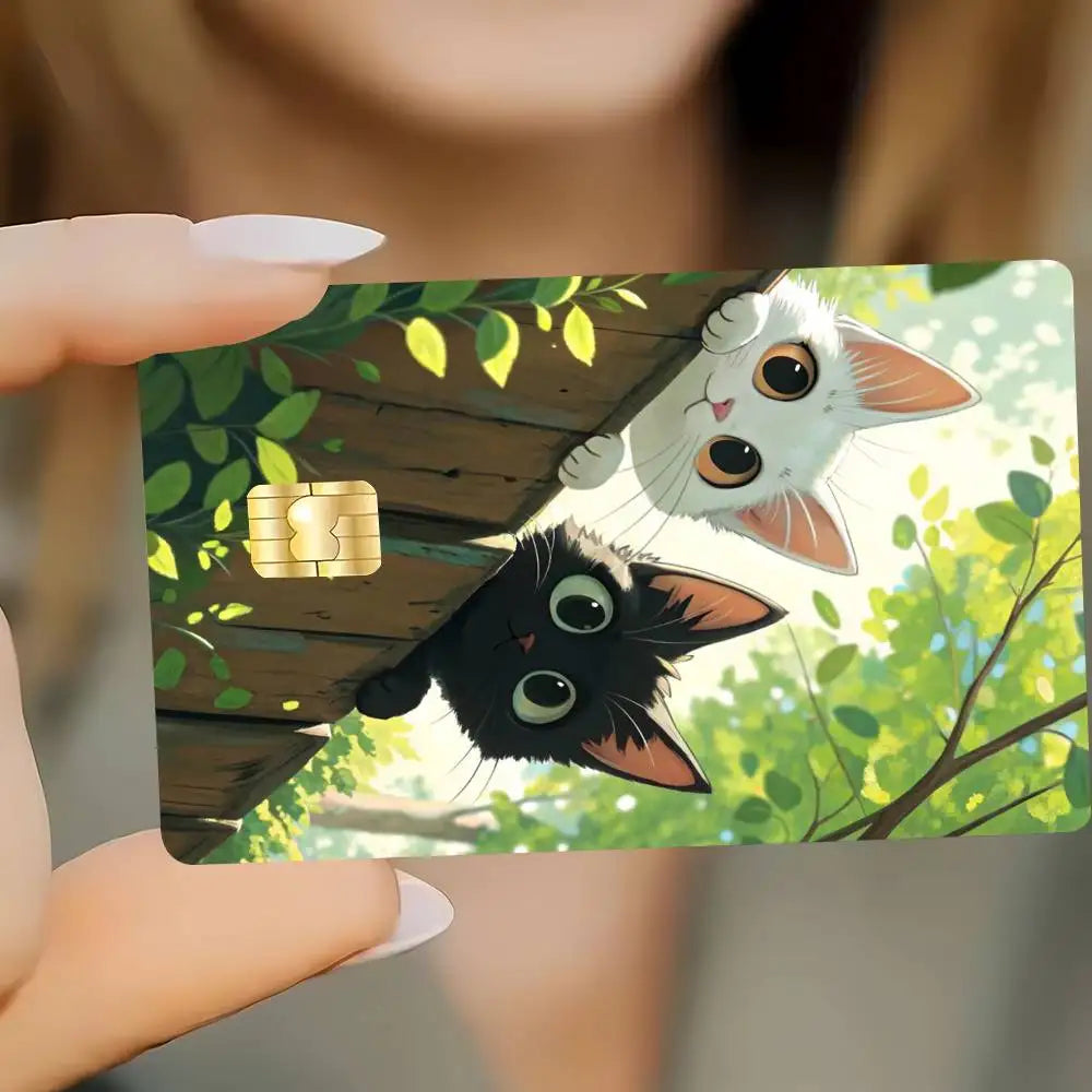 A card featuring illustrations of a black cat and a white cat against a green leafy background.