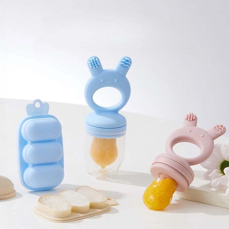 A set of silicone fruit food feeders and cooling molds in light blue and pink colors displayed on a white surface.