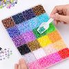 A hand is holding a clear plastic tray filled with various colors of flat-back rhinestones for DIY crafts.