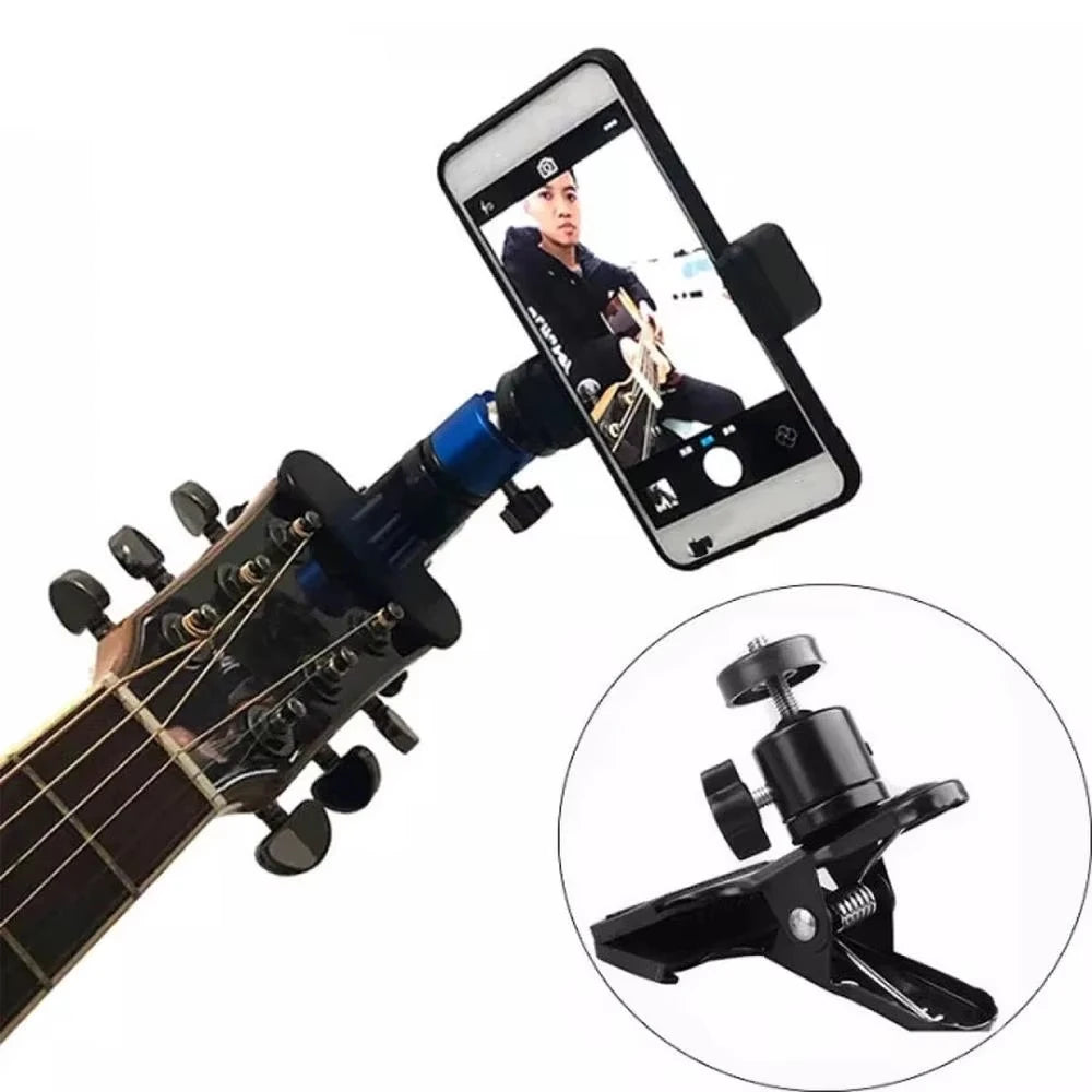 A black guitar headstock is clipped onto a smartphone for a 360-degree photo or video.
