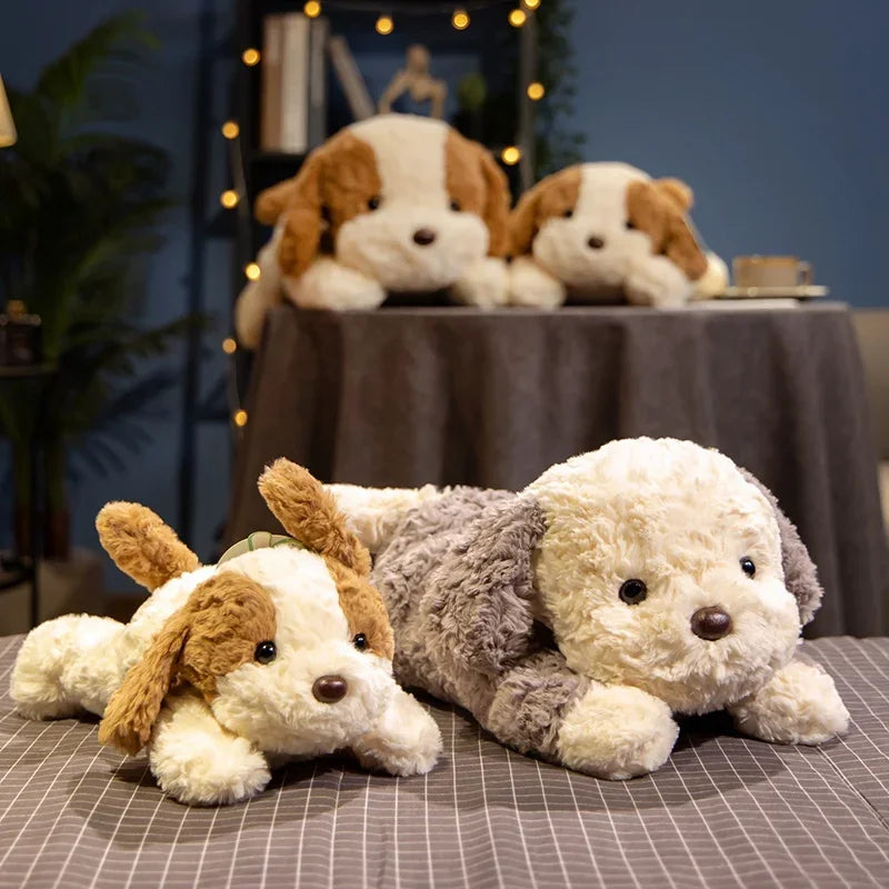 A plush toy of a light-colored dog lying down on a table, with other similar toys in the background.