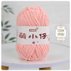 A ball of pink chenille yarn labeled for knitting and crochet is displayed on a white surface.