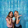 Two young women smiling and showing off a light blue ice cream cone against a bright blue vertical banner