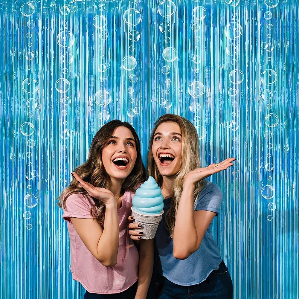 Two young women smiling and showing off a light blue ice cream cone against a bright blue vertical banner