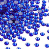 A close-up view of numerous round blue glass crystal rhinestones scattered on a white background.