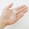 A hand holds a clear plastic storage bottle for diamond painting beads and crafts.