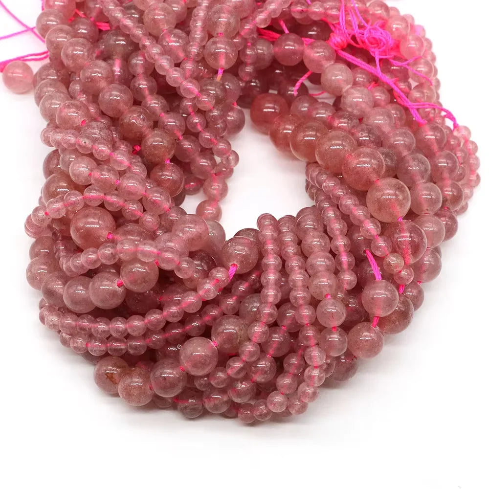 A tangled string of small, translucent pink and reddish-colored round beads for jewelry making.