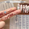 A hand displays various silicone nail molds shaped like bows and flowers, alongside a carving pen.