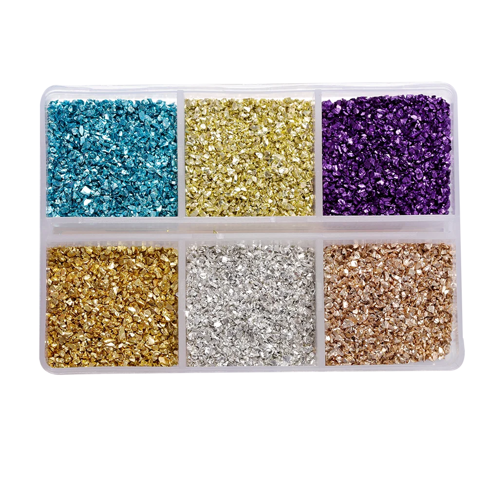A clear plastic tray filled with various colors of crushed glass stones including blue, gold, purple, silver, and bronze.