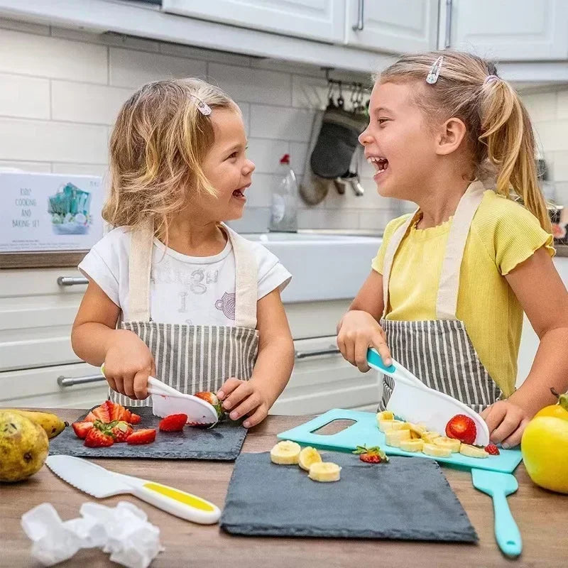 Two young children are using a kids cooking set with safe knives and tools to prepare food in a kitchen setting.