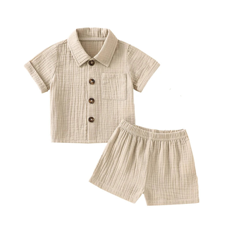 A beige knitted baby boy cotton linen shirt and matching shorts outfit set.