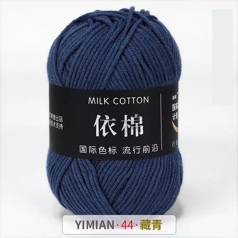 A skein of dark blue milk cotton yarn labeled with Chinese characters and a weight of 44 grams.