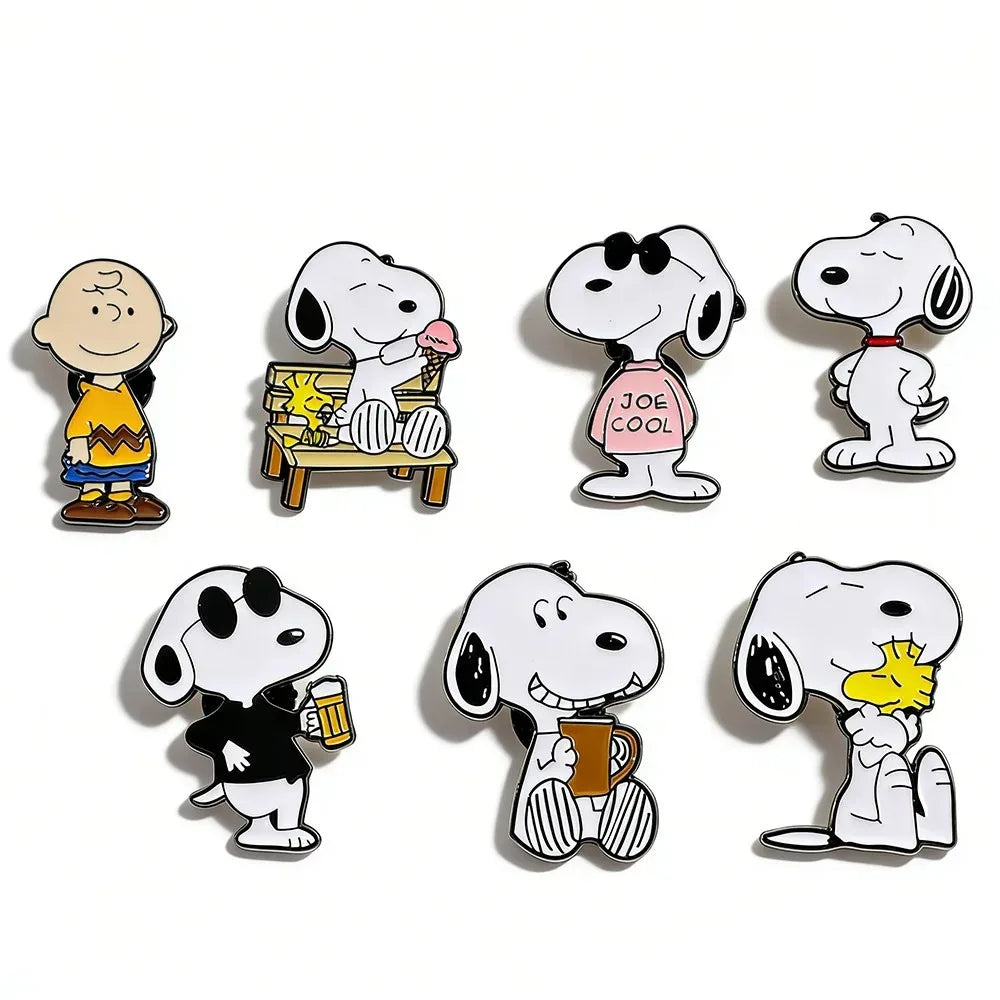 A set of seven enamel pins featuring Snoopy characters in various poses and scenes.